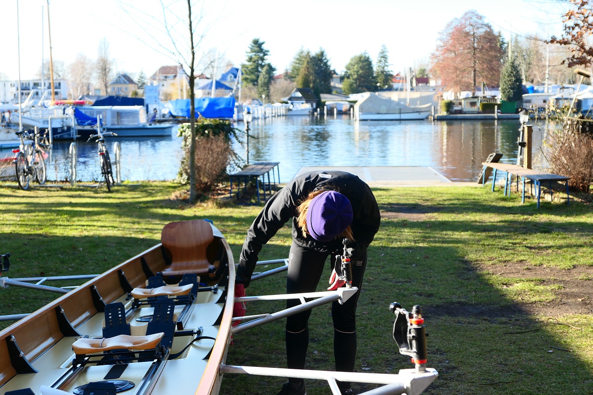 Eine Rudererin putzt das Boot nach dem Rudern